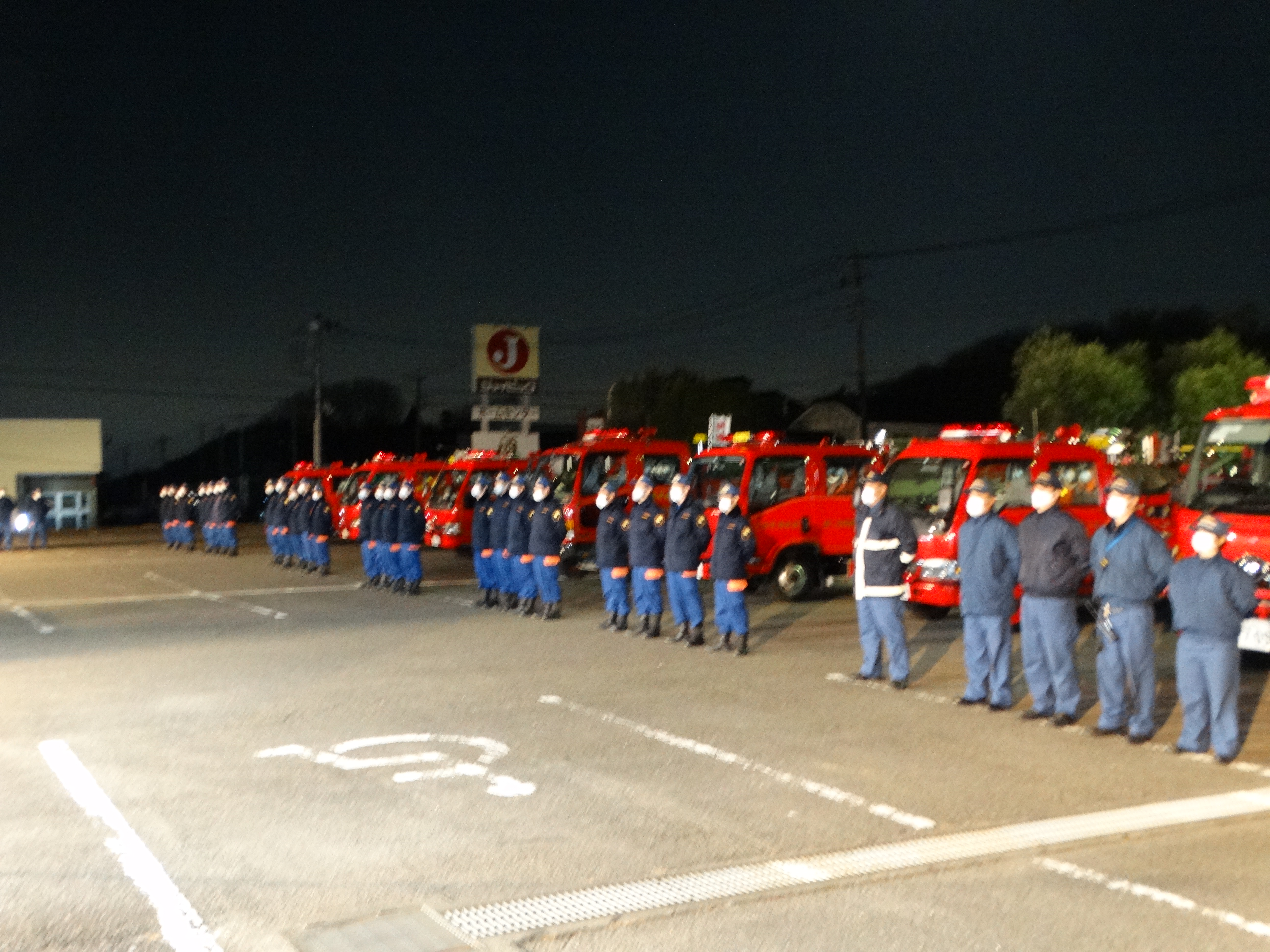 消防車の前に整列する消防団員