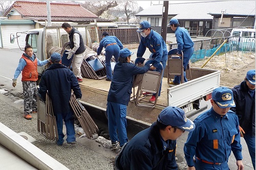 二中から備品を運び出す消防団員