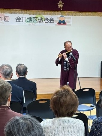 お祝いの笛を披露する森平町長